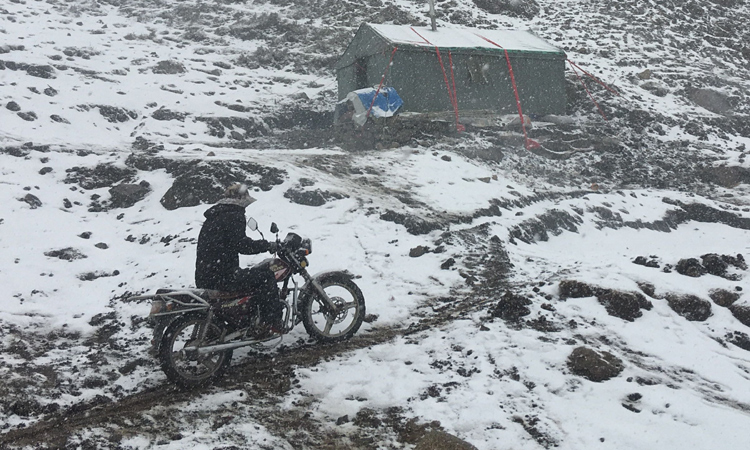 騎摩托的采挖者路過營地帳篷